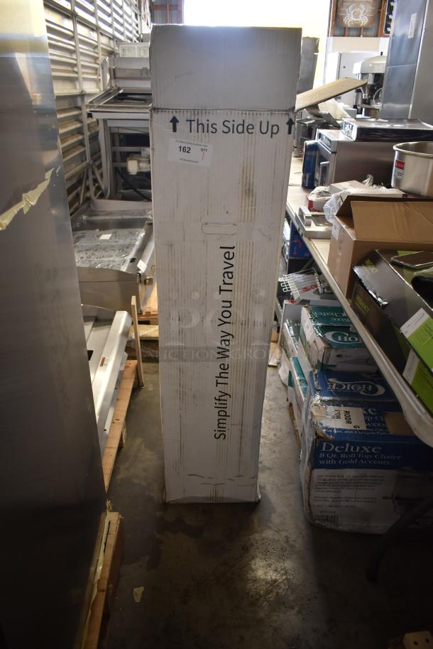 Brand new Hatco metal unit labeled "This Side Up" and "Simplify The Way You Travel," in original packaging, slight box wear.