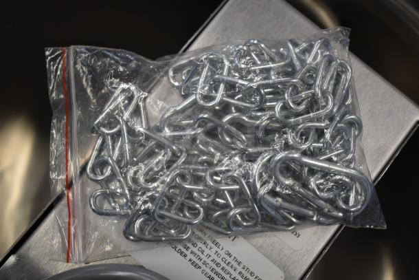 Bag of metal chain links, new condition, included with Edlund 266 can opener. Package shows maintenance instructions.