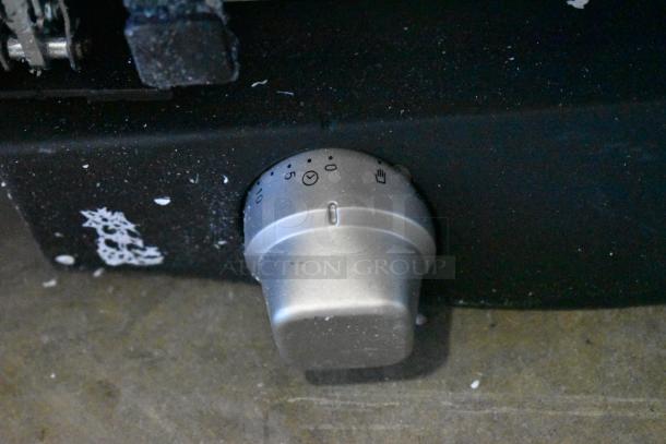 Control knob of the Cadco XAF013-US convection oven with time and temperature settings, showcasing its adjustment features.