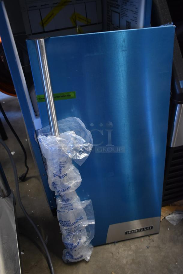 Brand new Hoshizaki AM-50BAK ice machine, stainless steel, undercounter model, 27 lb. bin, minor scratches, wrapped with protective film.