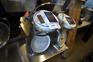 Two Cardinal Detecto SCS30 solar-powered hanging scales, 30 lb. capacity, good condition, with visible analog and digital displays.