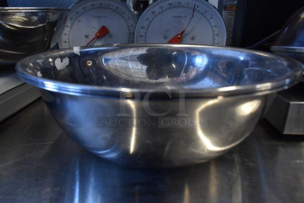 Metal countertop scale with dual red pointers and stainless steel bowl, some visible wear, ideal for precise measurements.