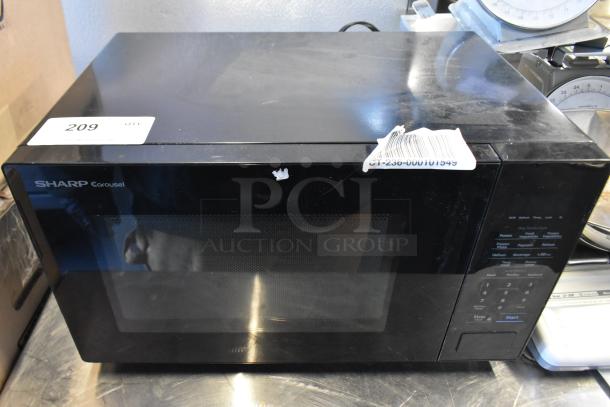Sharp SMC1131CB Countertop Microwave Oven, black, 120 Volts, 1 Phase, with plate. Visible control panel and minor exterior wear.