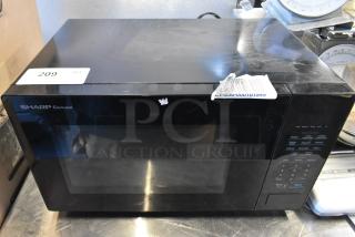 Sharp SMC1131CB Countertop Microwave Oven, black, 120 Volts, 1 Phase, with plate. Visible control panel and minor exterior wear.