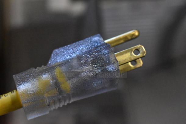 Alt text: Close-up of a transparent electrical plug with a yellow cord.