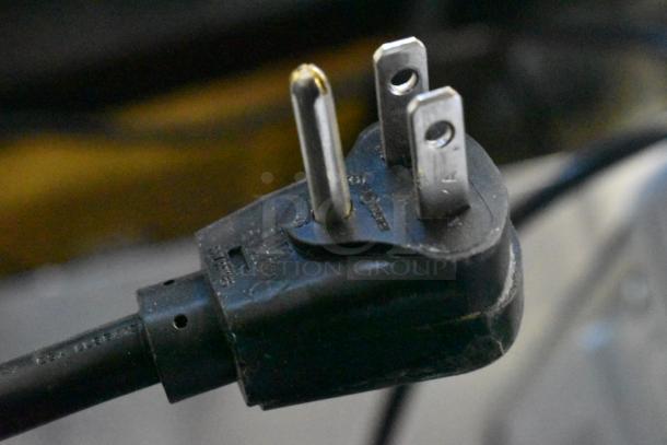 Close-up of a black three-prong plug for the 2021 Amana RCS10TS Commercial Microwave, 120 Volts, 1 Phase.