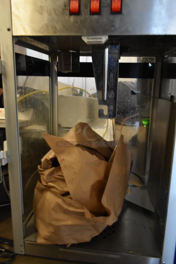 Metal commercial countertop popcorn maker merchandiser, 115 volts, 1 phase, visible red switches, interior paper bags.