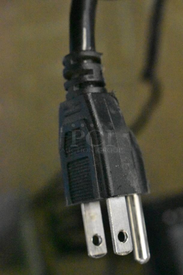 Power cord plug of a Metal Commercial Countertop Popcorn Maker Merchandiser, 115 volts, 1 phase. Black, standard prongs.