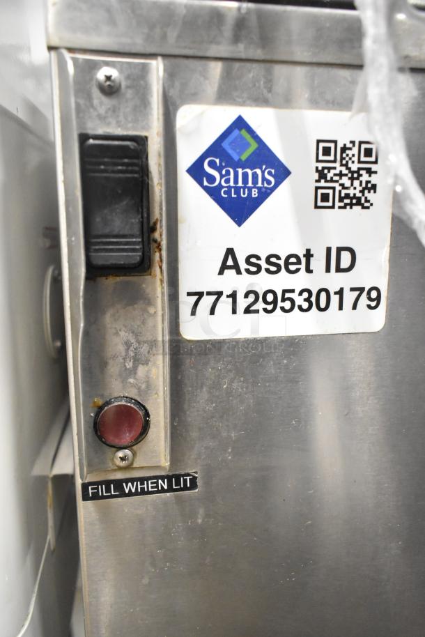 Stainless steel commercial washing/soaking tub with "Sam's Club" asset tag, toggle switch, and "Fill When Lit" indicator.
