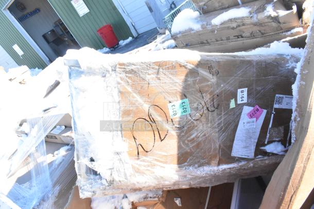 Four new scratch and dent items including gray posts, Carlisle sneeze guard, Bakers Lane ingredient bin, ice bin wrapped in plastic. Tags indicate condition and lot numbers.