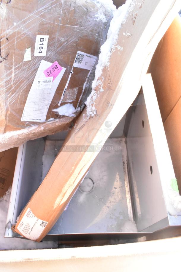 Four brand new scratch and dent items, including gray posts, Carlisle sneeze guard, Bakers Lane ingredient bin, ice bin in packaging.