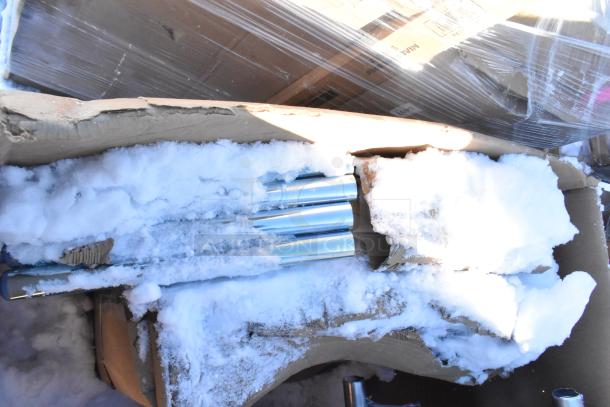 Four brand new scratch and dent items including gray posts, Carlisle sneeze guard, Bakers Lane ingredient bin, and ice bin, partially boxed with visible snow and packaging in a warehouse setting.