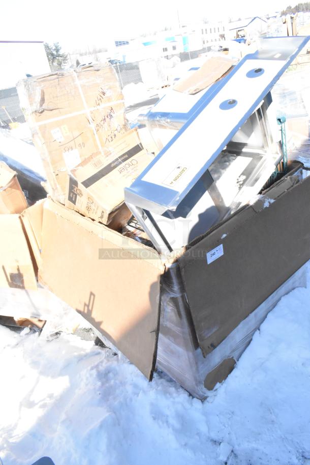 Box containing 12 new scratch and dent items including fryer and chafer, visible labeling and caution marking.