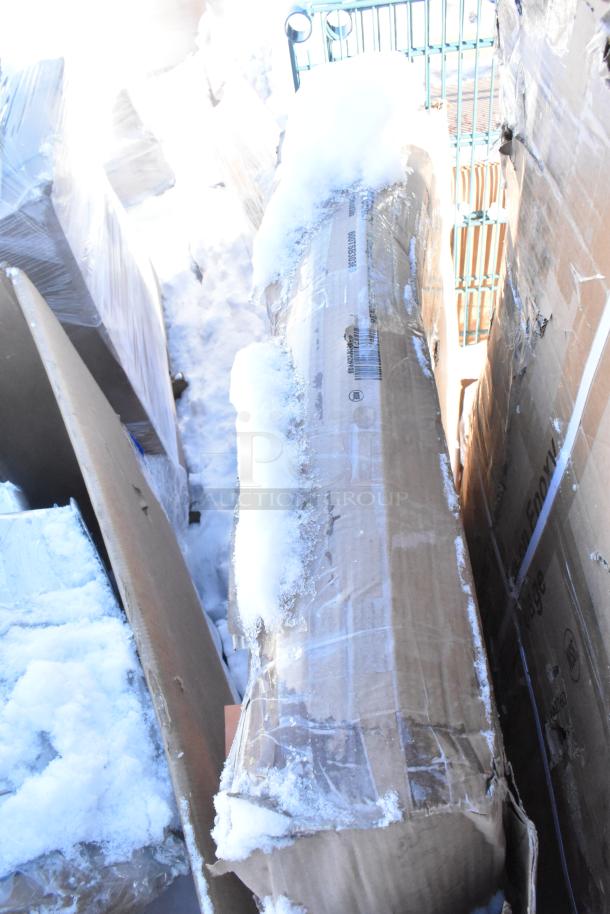 Cardboard boxes containing 12 new scratch and dent items, covered in snow. Packaging shows product labels; may include fryer, chafer.