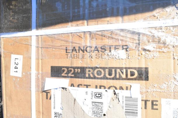 Cardboard box labeled "Lancaster Table & Seating, 22'' Round Cast Iron," showing packaging wear. Inventory tag L241 visible.