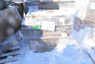 Eight brand new scratch and dent items, including a tabletop, wrapped in plastic on a snowy pallet. Labels indicate "Skid 40FΣ."