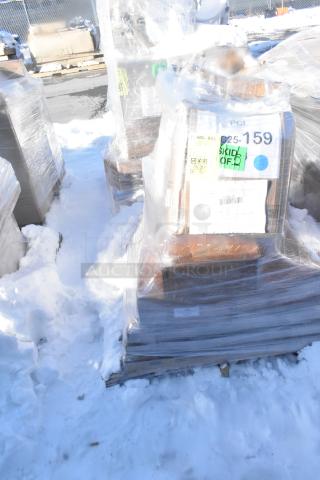Alt text: Pallet of shrink-wrapped items on snow, marked "C25-159", includes tabletops, wok, toilet dispenser in scratch and dent condition.