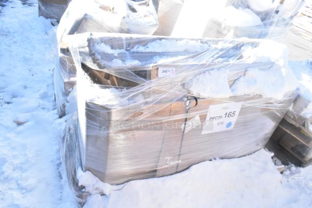 Five wrapped, brand new scratch and dent items, including a sink and overshelves, partially covered in snow, labeled "DEC25-165."