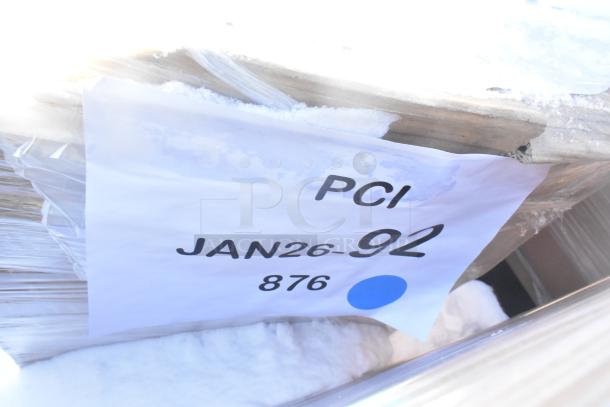 Four brand new scratch and dent items including a janitor cart, wrapped in plastic. Label marked "PCI JAN26-92 876" visible.