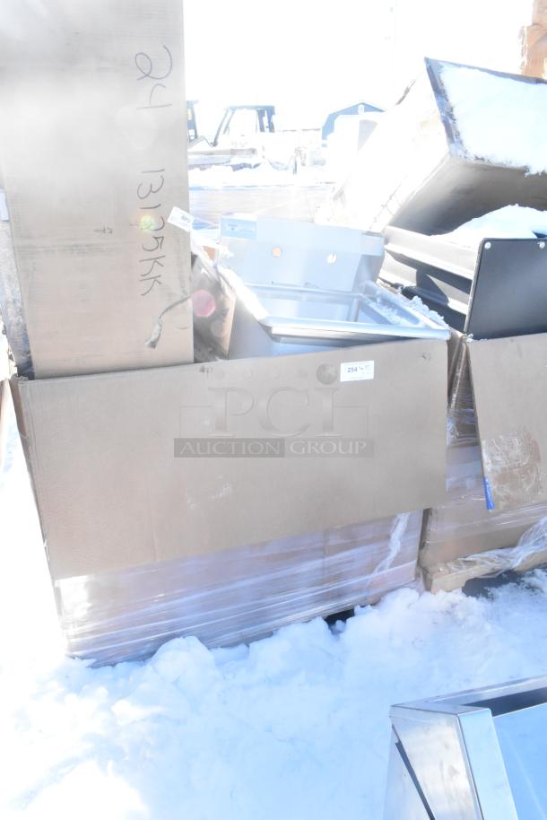 Boxed, new scratch and dent items on pallet; includes sink, bar stool, table base plate, and pot rack.