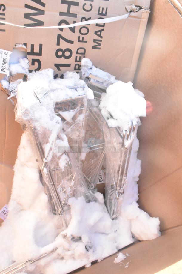 Box containing assorted scratch and dent items, including wrapped chrome pieces. Snow present, visible box markings.