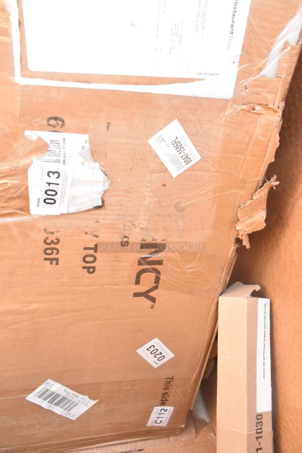 Damaged cardboard box with shipping labels, containing mixed new items like a sink, bar stool, table base, and pot rack.
