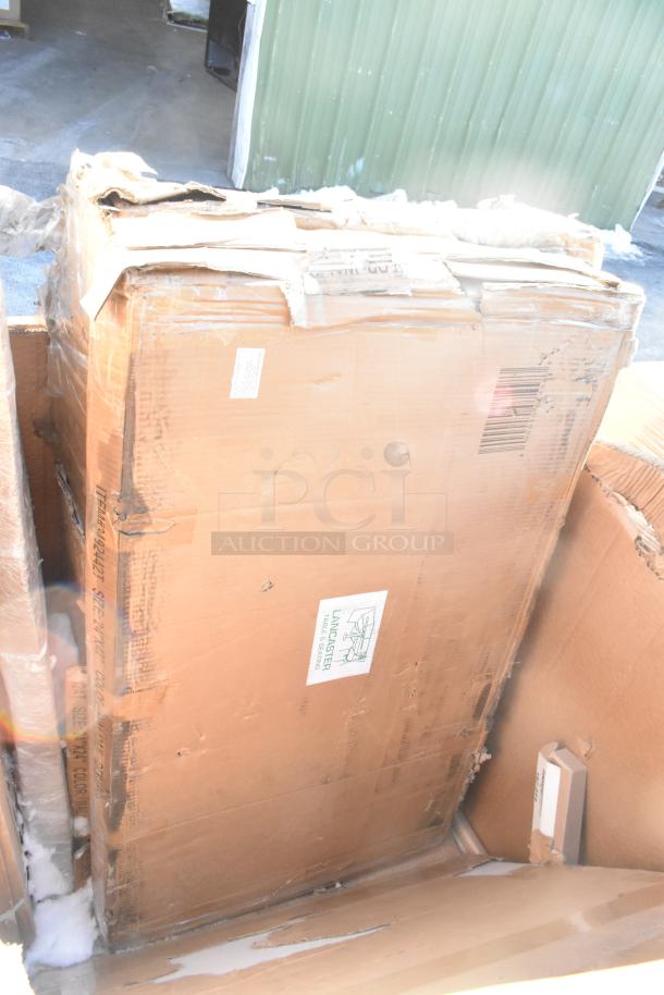 Large cardboard box containing new scratch and dent items, including a sink and bar stool, with visible Lancaster label.