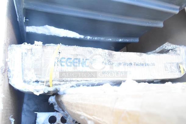 Stacked boxes labeled "Regency," showing contents including a 24x30 work table, 60-quart container; boxes show wear.