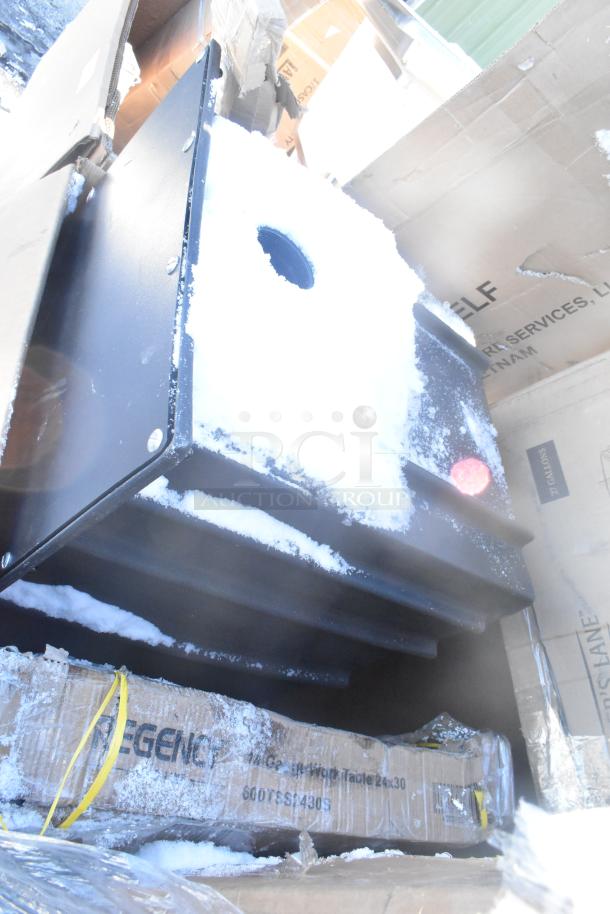 Seven brand new "scratch and dent" items including a Bakers Lane ingredient bin, Regency table, and pan racks, packaged in boxes with visible snow and storage wear.