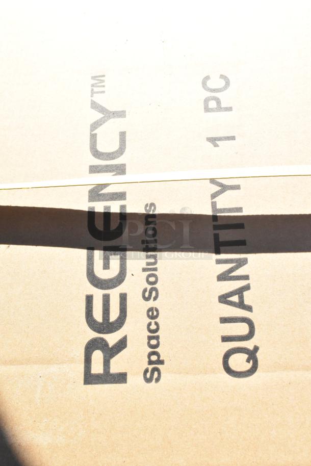 Cardboard box labeled "REGENCY Space Solutions, Quantity 1 PC." Contains scratch and dent items including shelves and baby changing station.