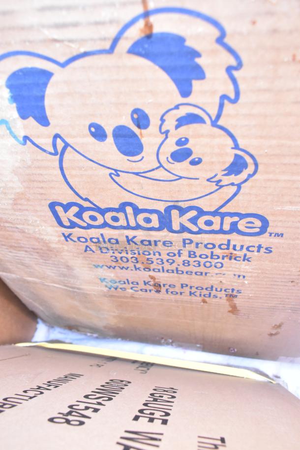 Cardboard box with Koala Kare branding. Contains scratch and dent items including shelves and a baby changing station.
