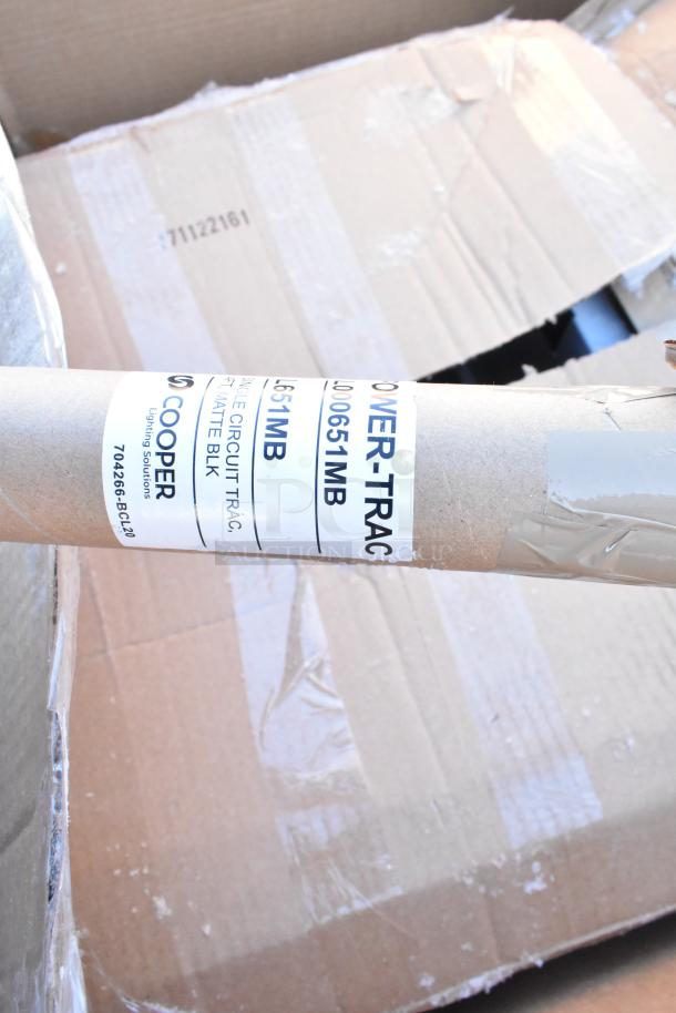 Cardboard tube labeled "POWER-TRACK" by Cooper Lighting, placed over damaged boxes.