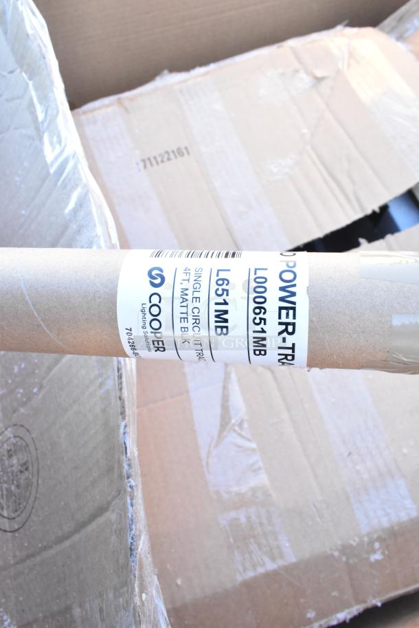 Cardboard box labeled "Cooper Lighting Solutions, Single Circuit Track, 4 FT, Matte Black," indicating new condition items.