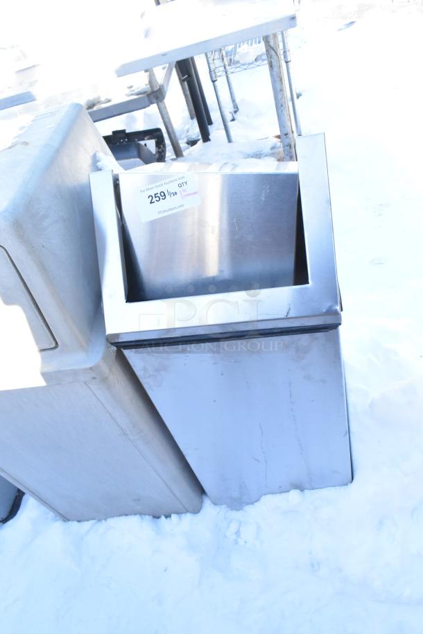 Stainless steel trash can shell with swinging flap lid, slight wear, label indicating auction item 259.