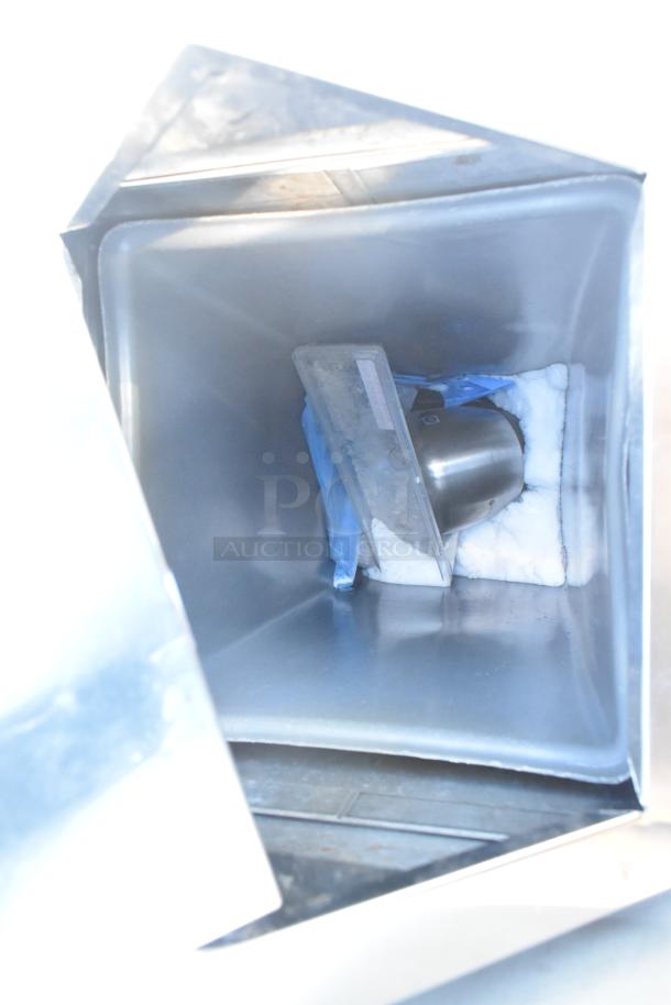 Stainless steel trash can shell with a swinging flap lid, showing interior condition and features.