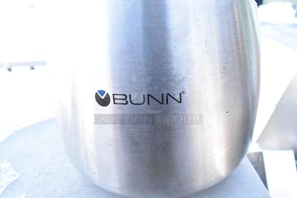 Stainless steel trash can shell with a swinging flap lid, featuring the Bunn logo, minor surface scratches visible.