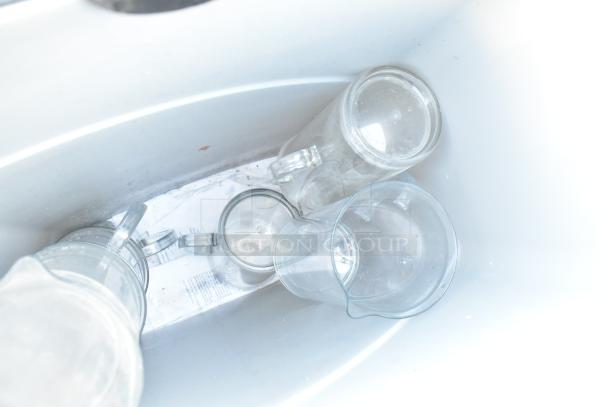 Poly trash can with a smooth interior, containing four clear plastic pitchers. Clean condition, no visible damage.