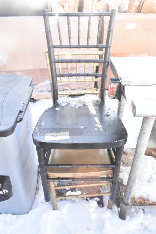 Two Chiavari stackable banquet chairs, black with gold detailing. Some ice and wear visible. Label reads "262."
