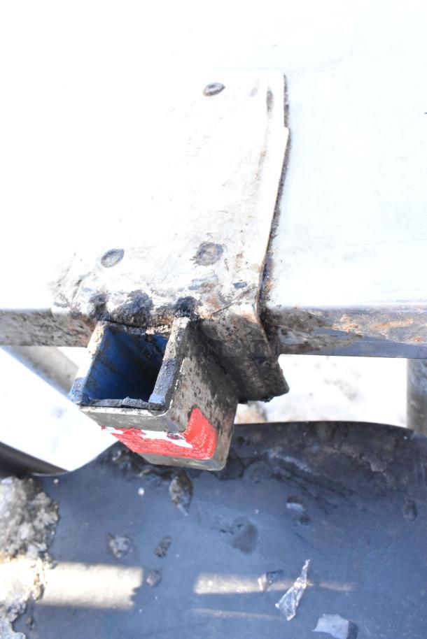 Stainless steel table corner with metal under shelf and commercial can opener mount. Signs of wear visible.