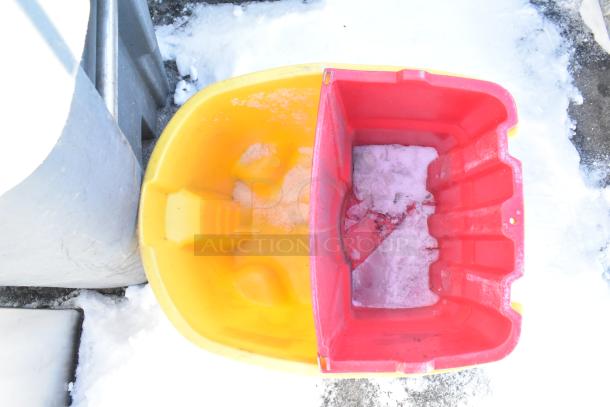 Rubbermaid yellow poly mop bucket with wringing attachment on commercial casters, showing signs of use.