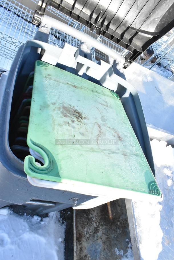 Poly trash can containing plastic cutting boards, showing moderate wear and scratches.