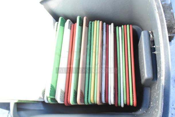 Poly trash can containing multiple colored cutting boards, used condition.