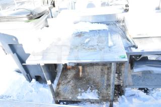Stainless steel table with metal under shelf, visible rust and snow, used condition. Table has identification tag "267".