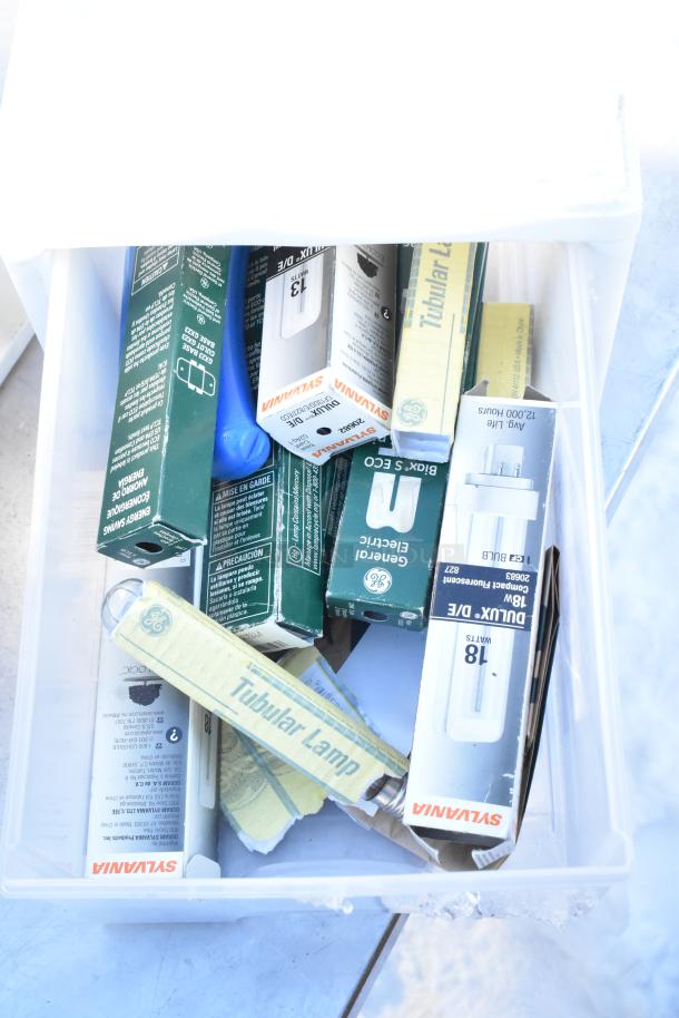 Various items including Sylvania bulbs, GE light tubes, and poly drawers. Items appear in packaging, suggesting new condition.
