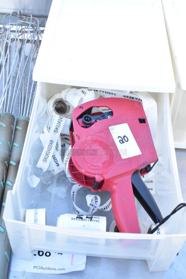Plastic poly drawer containing red pricing gun, label rolls, series of whisks, and tags labeled with SKU numbers.