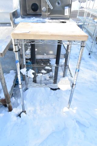 Chrome finish 2-tier wire shelving unit with wooden top, used condition. Features adjustable shelves, ideal for storage.