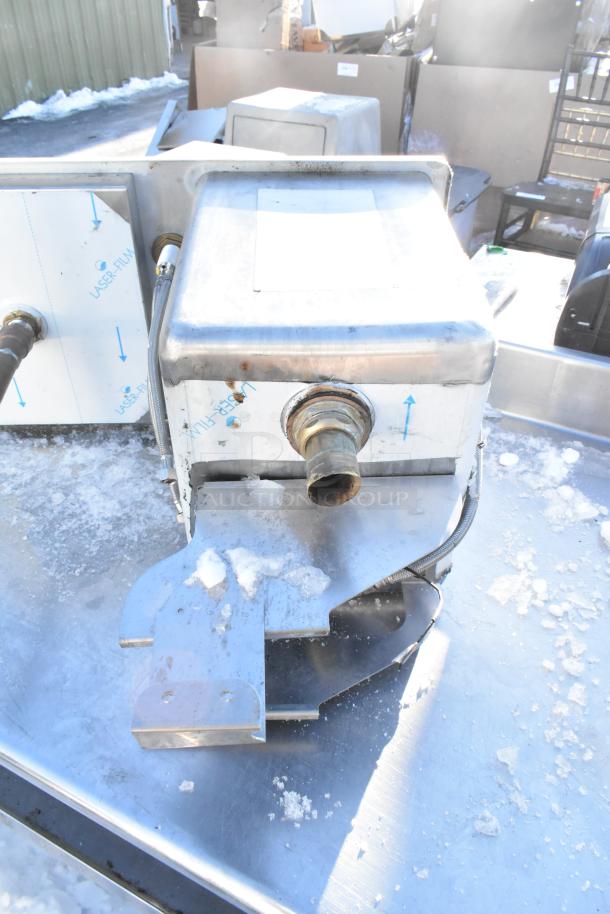 Stainless steel drop-in sink in used condition, showing plumbing connections and some surface scratches.