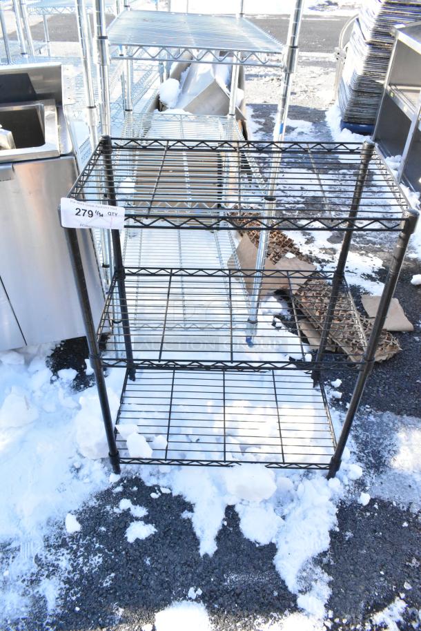 Black 3-tier wire shelving unit, weathered condition, snow-covered ground, labeled with "279" tag. Buyer dismantles.
