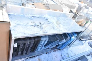 Regency 600EBTB2472 stainless steel table with snow-covered surface, enclosed base, midshelf, 6" backsplash, and dish caddies.