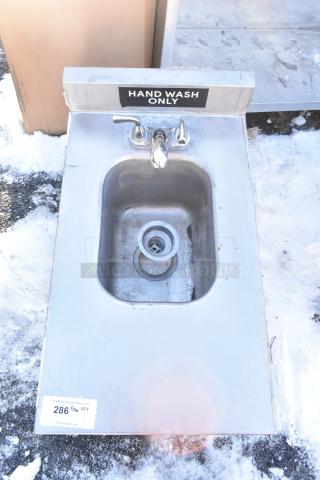 Stainless Steel Single Bay Sink, no legs, hand wash only label, faucet and drain visible. Top view, outdoor setting.
